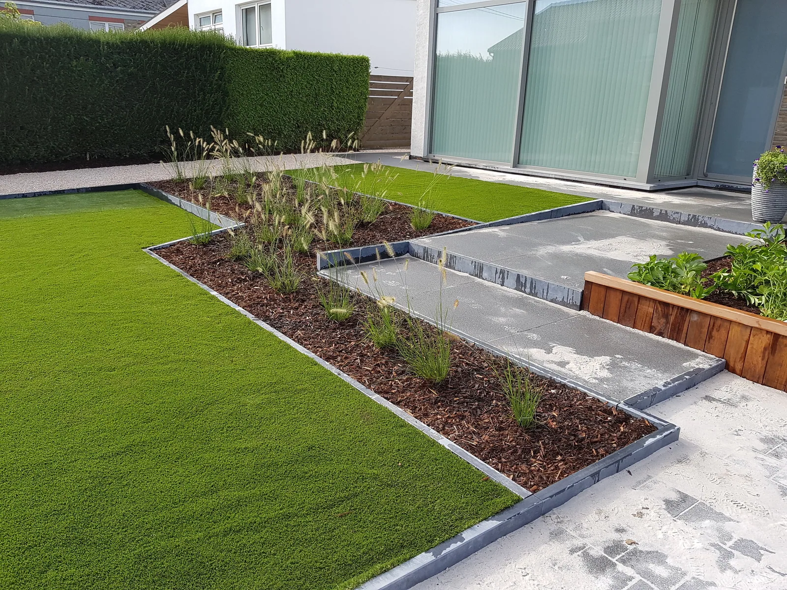 Strak aangelegde moderne tuin met gazon, borders en trap — Lumen bv